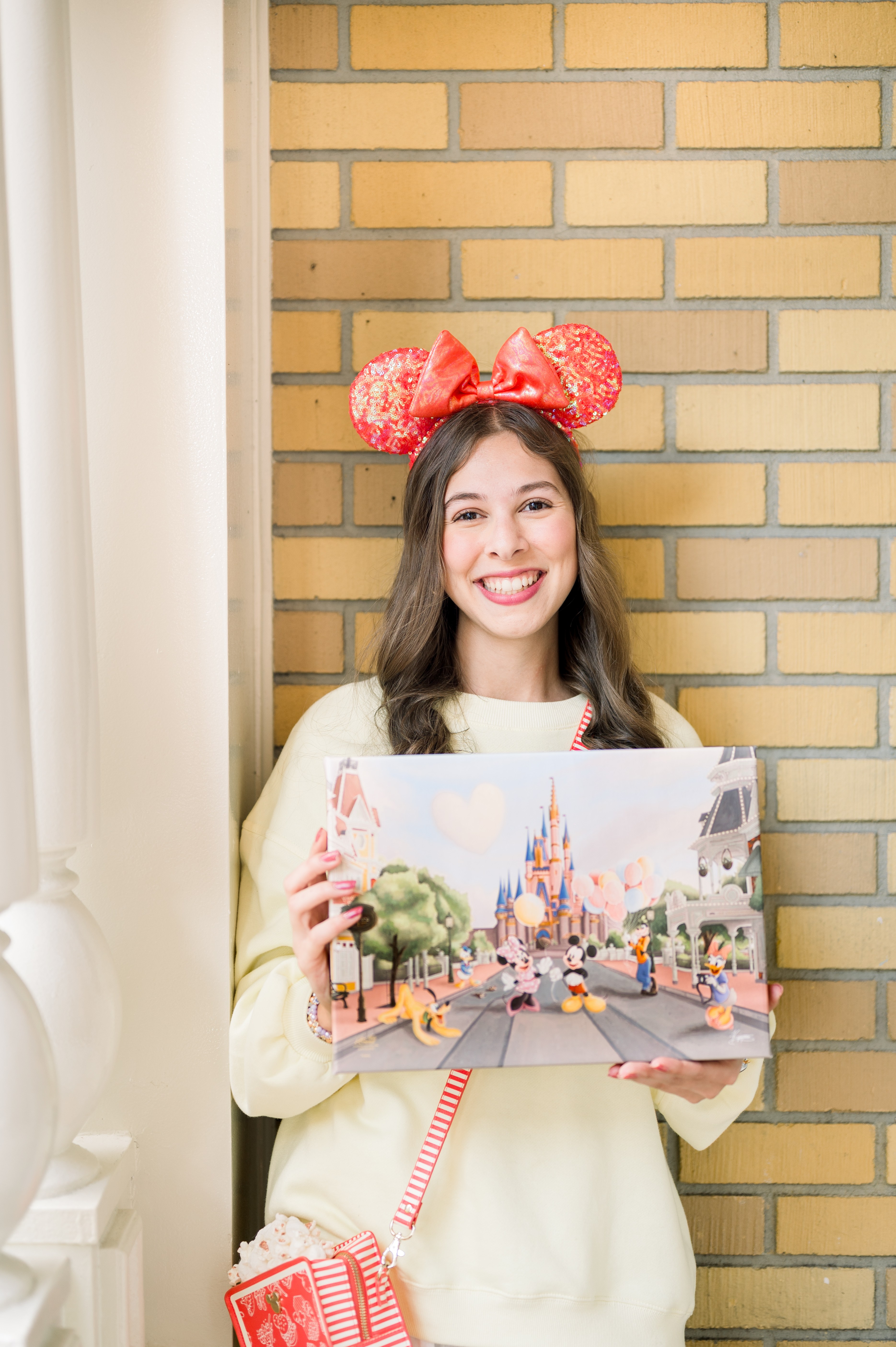 Kyree wearing Mickey ears and holding her Main Street USA artwork