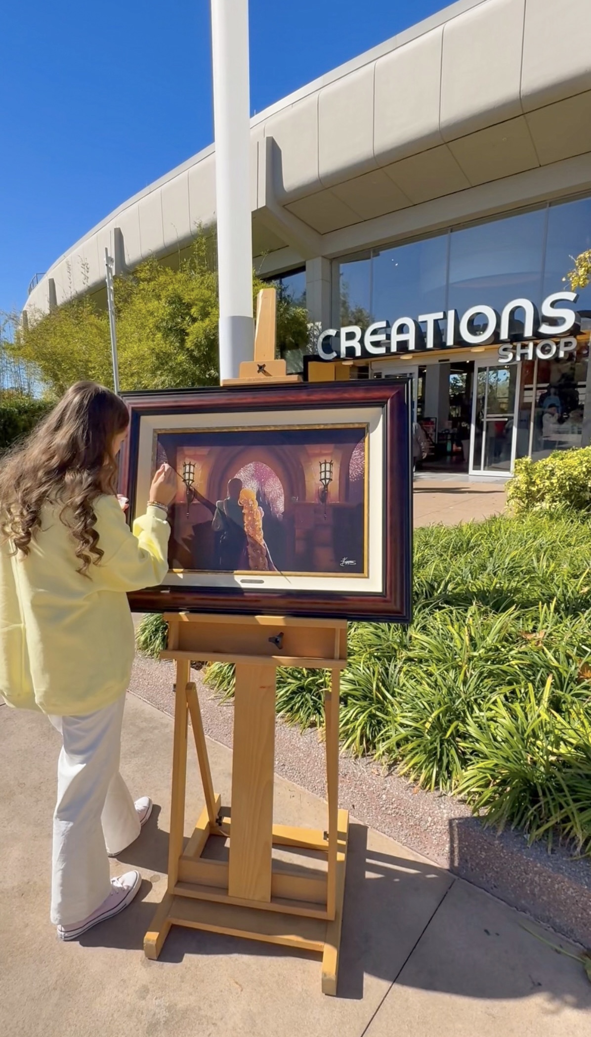 Kyree displaying her Rapunzel painting at EPCOT Creations Shop