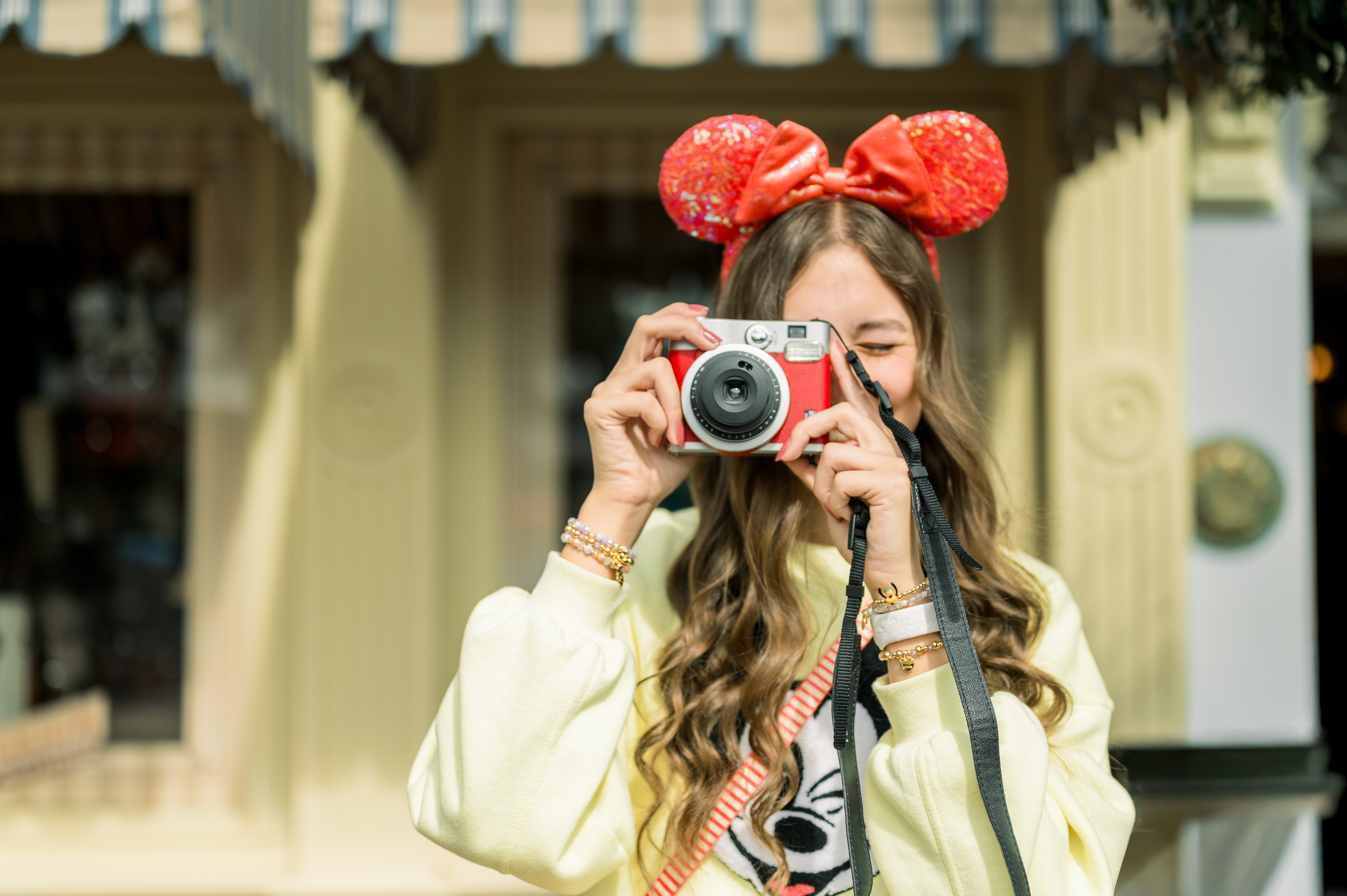 Kyree Tilsher wearing Minnie ears and taking a photo at Disney Parks